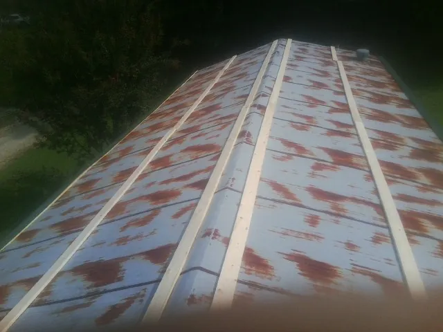 Rusted metal roof panels with new wood purlins before replacement — Storm Damage Roof Repair in Raymondville by Roofing Brothers