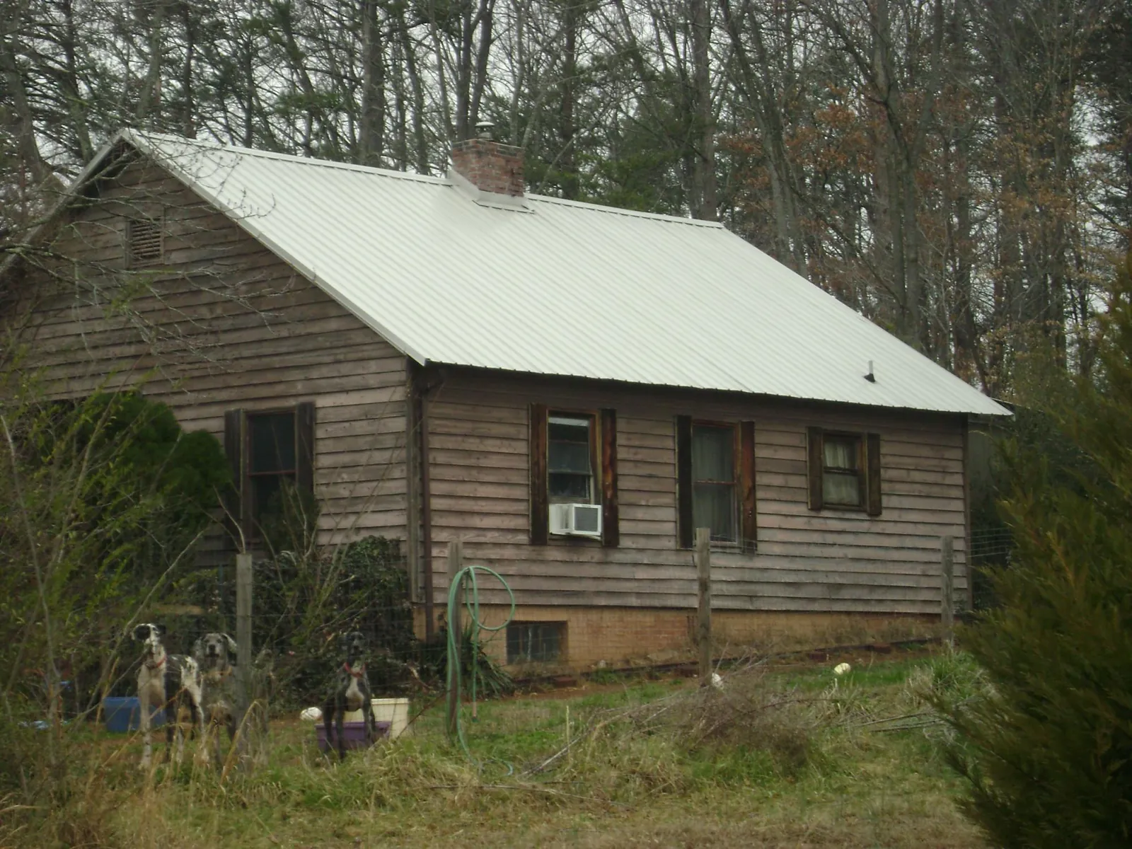 White metal roof on an old wood sided farmhouse, from a Metal Roof Installation job in Raymondville